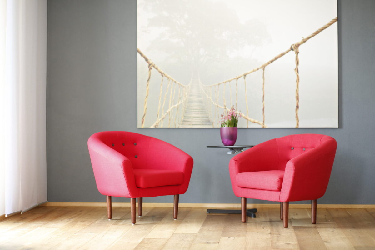 2 rote Sessel vor dem Bild einer Hängebrücke